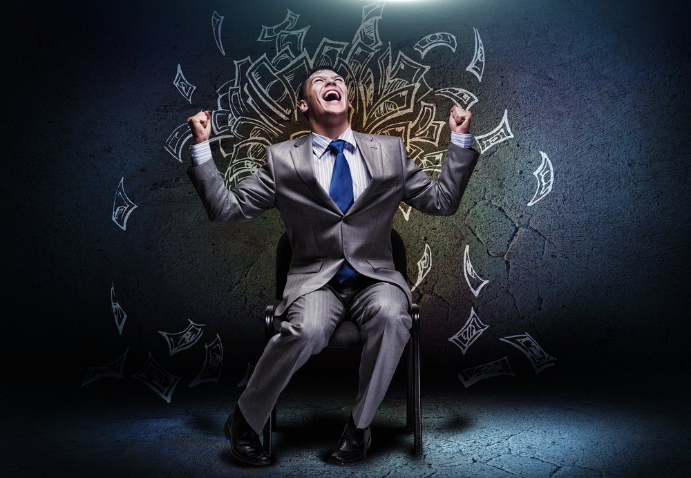 Joyful businessman sitting on chair under money rain.jpeg